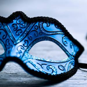Close up image of a blue masquerade mask with glitter detailing.