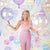 Image of a woman surrounded by floating bobo and bubble balloons in different transparent hues, there are purple, pink, blue, clear and yellow balloons in the image.
