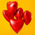 Image of a balloon bouquet that is made up of red heart shaped foil balloons.