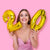 Image of a woman holding a gold 2 and 0 number balloon in each hand.
