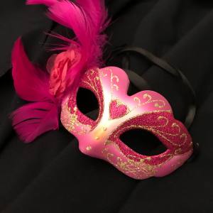 Image of a pink masquerade mask with glitter details and a pink feather to one side.