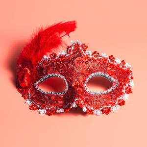 Image of a red lace masquerade mask with feather to one side.