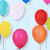 Image of multiple round balloons floating in the air.